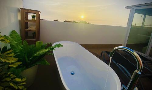 baño con bañera blanca y planta en Big House Adeje Deluxe By Deihu Experiences, en Adeje