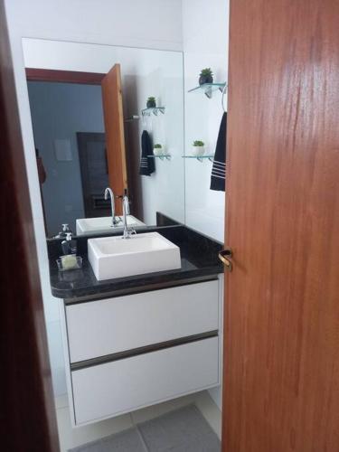 a bathroom with a sink and a mirror at Agradável apartamento perto da praia in Florianópolis