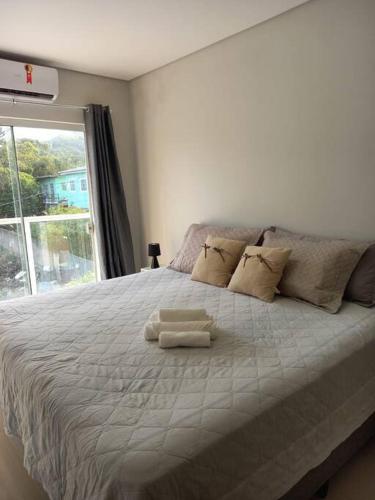 1 dormitorio con 1 cama grande y 2 toallas. en Agradável apartamento perto da praia, en Florianópolis