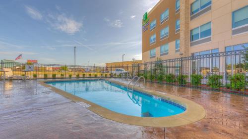 una piscina di fronte a un edificio di Holiday Inn Express & Suites Tulsa Midtown, an IHG Hotel a Tulsa