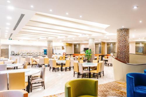 Holiday Inn Express Shanghai Putuo, an IHG Hotel في شانغهاي: غرفة طعام مع طاولات وكراسي