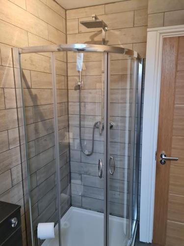 a shower with a glass door in a bathroom at Cullen Holiday Home in Cullen