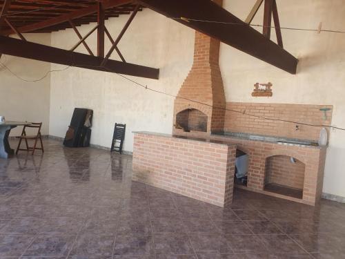 a brick fireplace in a room with a table at Casa temporada da Nenê in Ipitangas