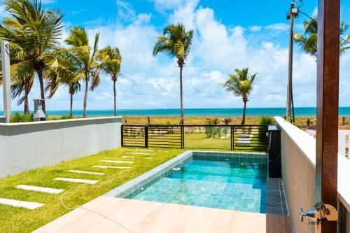 eine Villa mit Swimmingpool und Blick auf das Meer in der Unterkunft Portal beira mar (casa) in Tamandaré