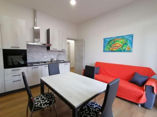 a living room with a table and a red couch at Calipso casa vacanza in La Spezia