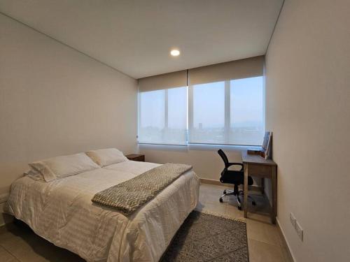 een slaapkamer met een bed, een bureau en een raam bij Cómodo Departamento in Mexico-Stad
