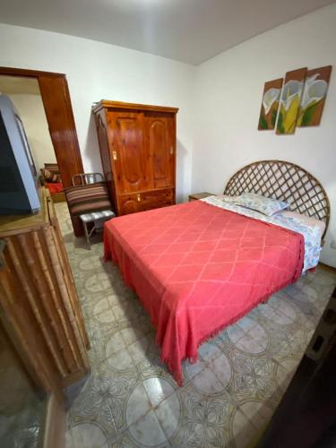 1 dormitorio con 1 cama con manta roja en Madaguequa en Villa Gesell