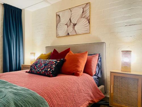a bedroom with a bed with colorful pillows on it at Seddon Studios in Melbourne