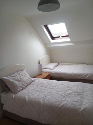 a bedroom with two beds and a skylight at 33B Steepleview in Trim