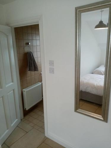 1 dormitorio con espejo y 1 cama en una habitación en 33B Steepleview, en Trim