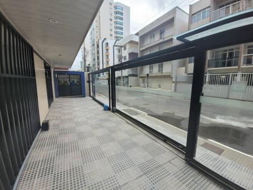 an empty hallway of a building with glass doors at Apt na quadra da praia do Morro com área Lateral in Guarapari