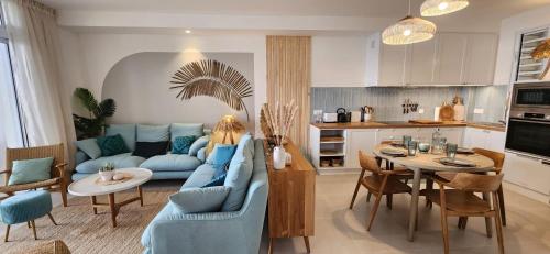 Paea的住宿－White Palm，客厅配有蓝色的沙发和桌子