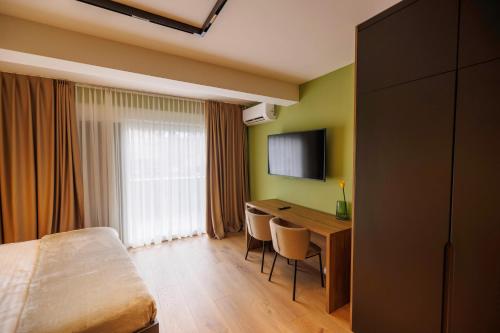 a hotel room with a bed and a desk and a television at 1863 Boutique Hotel in Peje