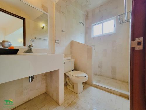 a bathroom with a toilet and a sink and a mirror at Hotel Puente Nacional & Spa in Puente Nacional