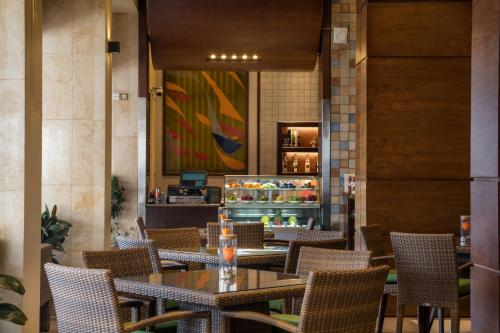 a restaurant with tables and chairs and a counter at Crowne Plaza Amman by IHG in Amman
