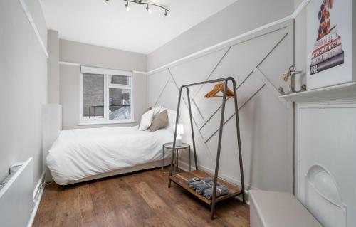a small bedroom with a bed and a window at Stylish apartment in the heart of Kingston town centre in Kingston upon Thames