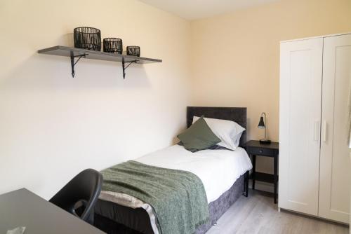 a bedroom with a bed and a desk with a chair at Beautiful 5 single bedroom house in Dagenham