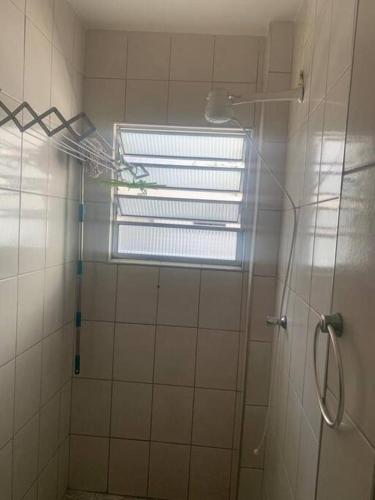 a bathroom with a shower with a window at Kitnet para temporada 600 m Praia do Gonzaguinha in São Vicente