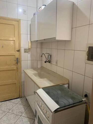 a small kitchen with a sink and a stove at Kitnet para temporada 600 m Praia do Gonzaguinha in São Vicente