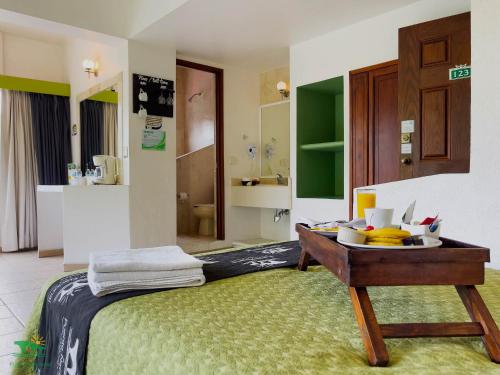 a room with a bed with a tray of food on it at Hotel Puente Nacional & Spa in Puente Nacional