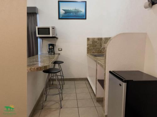 a small kitchen with a counter and stools in a room at Hotel Puente Nacional & Spa in Puente Nacional