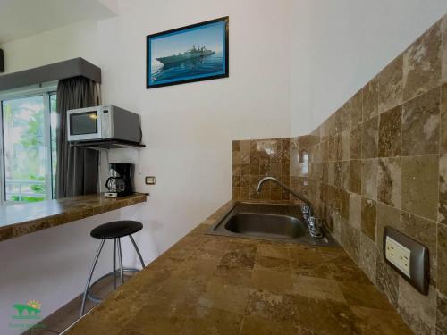 a kitchen with a sink and a tv on the wall at Hotel Puente Nacional & Spa in Puente Nacional