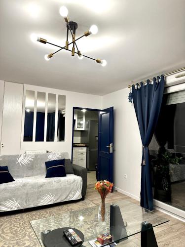 ein Wohnzimmer mit Sofa und Tisch in der Unterkunft Proche stade de France avec parking in Saint-Denis