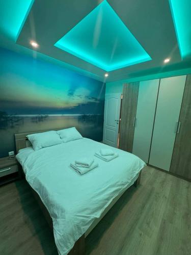 - une chambre avec un grand lit et un plafond bleu dans l'établissement Apartman ARENA Doboj, à Doboj