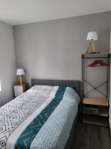 - une chambre avec un lit et une table avec une lampe dans l'établissement BONHEUR, à La Souterraine