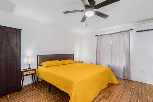 a bedroom with a yellow bed with a ceiling fan at Phoenix Retreat - 1 Bedroom King Suite with 2 Smart TVs - 10 min from Airp - Unit B in Phoenix