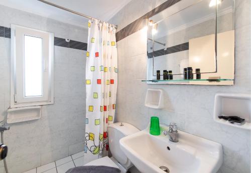 uma casa de banho branca com um lavatório e um WC em Hotel Selini em Ayios Nikitas