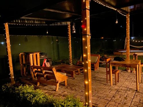 un patio con bancos, una mesa y luces en Cabaña Alpina SEAL, en Oxapampa