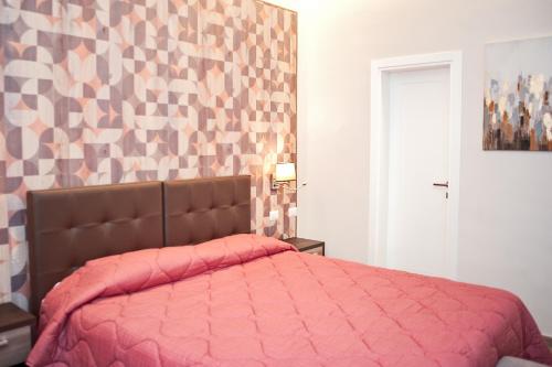 a bed with a pink comforter in a bedroom at SCIPIO92HOME in Rome