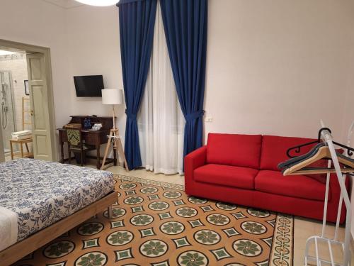 een woonkamer met een rode bank en een bed bij Civico 43 in Messina