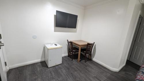 a room with a table and a television on the wall at Airport Motel - Inglewood in Inglewood