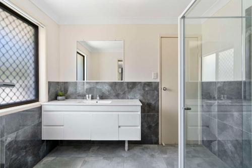 un bagno con un lavandino bianco e una doccia di Econo Lodge Waterford a Loganlea