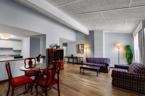 a living room with a table and a couch at Clarion Inn Falls Church-Arlington in Falls Church