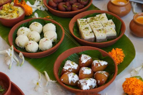 a table with bowls of food on a green leaf at Radisson RED Chandigarh Mohali in Chandīgarh