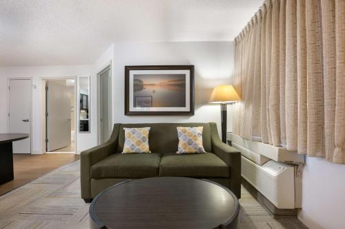 a living room with a couch and a table at Sonesta Simply Suites Huntsville Research Park in Huntsville