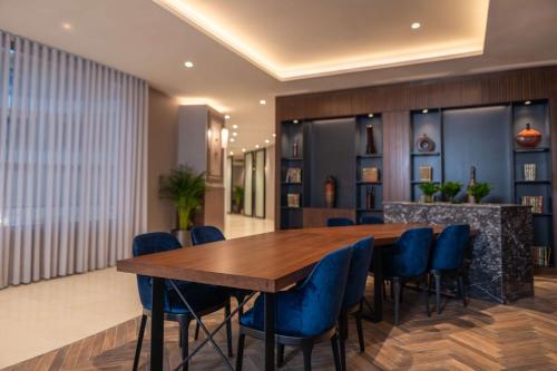 a dining room with a wooden table and blue chairs at Radisson Blu Hotel, Amman Galleria Mall in Amman