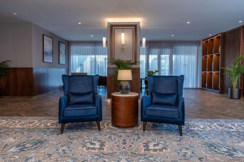 a lobby with two blue chairs and a table at Radisson Blu Hotel, Amman Galleria Mall in Amman
