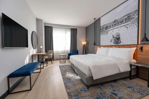 a hotel room with a large bed and a desk at Radisson Blu Hotel, Amman Galleria Mall in Amman