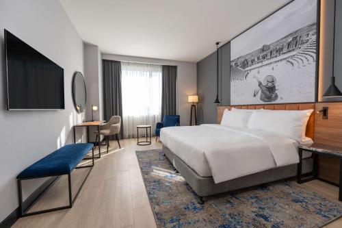 una camera d'albergo con un grande letto e una scrivania di Radisson Blu Hotel, Amman Galleria Mall ad Amman