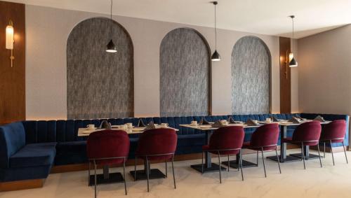 a dining room with tables and red chairs at Radisson Blu Hotel, Amman Galleria Mall in Amman