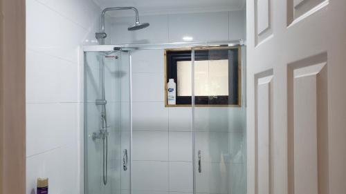 uma cabina de duche em vidro numa casa de banho com uma janela em Cabaña Bosque Rio em Puerto Varas