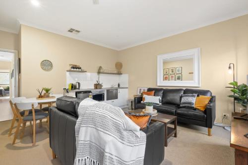 ein Wohnzimmer mit einem Sofa und einem Tisch in der Unterkunft Marcotta Guest Suite - Moments to Golf Course in Orange