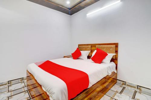 Hotel CG Inn pool rooftop في آغْرا: غرفة نوم بسرير ومخدات حمراء