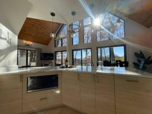 uma grande cozinha com armários de madeira e janelas em Tranquil Waterside Oasis em Benton Harbor