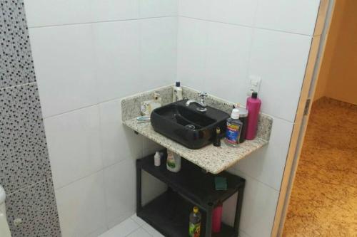 uma casa de banho com um lavatório na parede em Casa dos Bento em Contagem