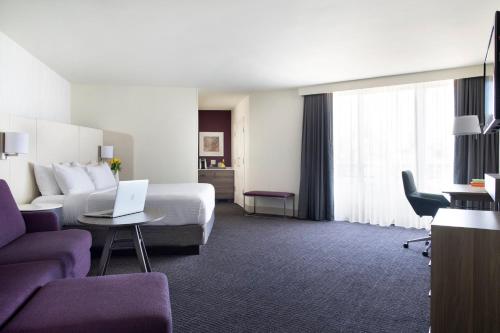 a hotel room with a bed and a laptop on a table at Crowne Plaza Atlanta Perimeter at Ravinia by IHG in Atlanta